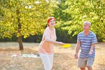 Glückliches Paar Senioren spielt Frisbee
