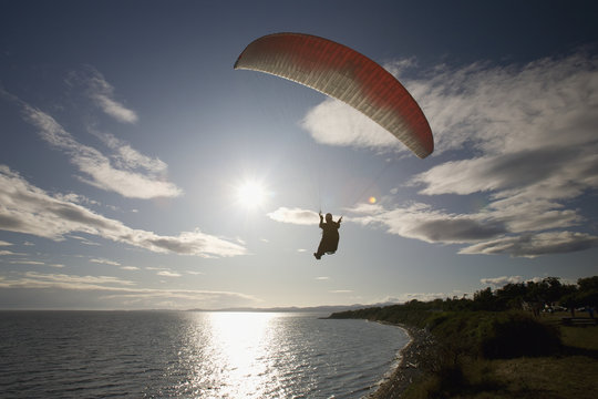 A Man Paragliding Along The Cliffs At Dallas Road; Victoria, Vancouver Island, British Columbia, Canada