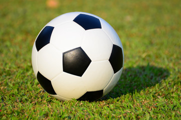 football or soccer ball on green grass field