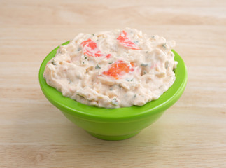Lobster dip in green bowl on wood table top side view.