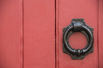 Iron doorknocker on red doors