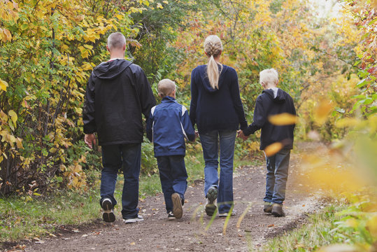 Family Walking Together On A Path In A Park In Autumn; Edmonton, Alberta, Canada