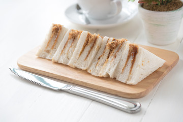 finger sandwiches triangles in wooden plate on white table