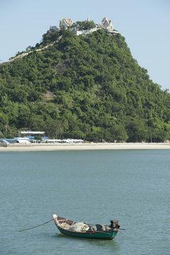 Boat On Water And A Hill In The Background; Prachuap Kiri Khan, Prachuap Province, Thailand