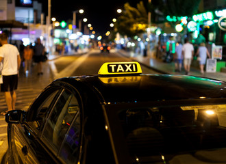 Taxi sign on the roof of a taxi at night