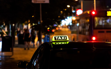 Taxi sign on the roof of a taxi at night