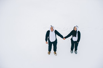 winter love story, a beautiful young couple in suits pandas