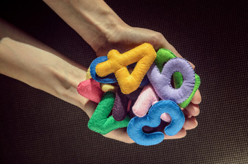 Colorful felt symbols in human palms