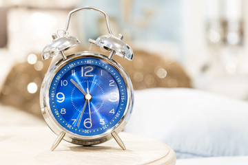 Vintage alarm clock on night table in bedroom