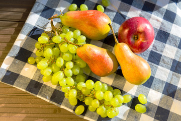 Grapes, pears and apples on a rustic wooden background