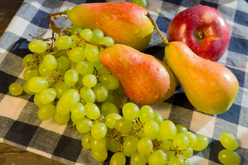 Grapes, pears and apples on a rustic wooden background
