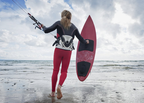 A Young Woman With Her Equipment For Kite Surfing On Dos Mares Beach; Tarifa, Cadiz, Andalusia, Spain