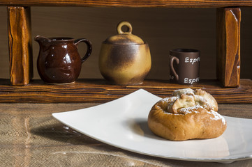 kompozycja z kołaczykiem drożdżowym makiem serem i rodzynkami na białym talerzyku i drewnianymi elementami, yeast dough with poppy seeds