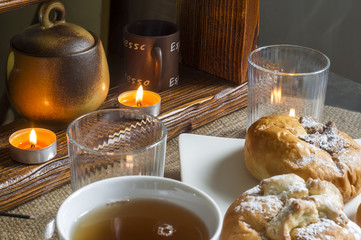 kompozycja z kołaczykiem drożdżowym makiem serem i rodzynkami na białym talerzyku i drewnianymi elementami, yeast dough with poppy seeds