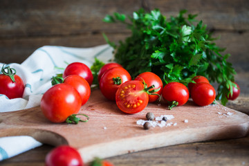 Fresh tomatoes with herbs on a kitchen board