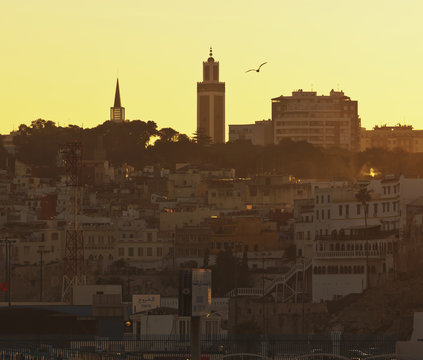 Skyline At Dusk With The Minaret Of Mohammed V Mosque Centre And Spire Of Roman Catholic Church To Left; Tangiers, Morocco