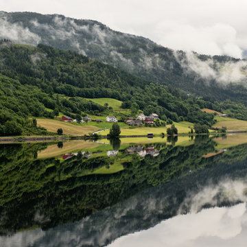 Houses in valley along water with low cloud, Granvin, Norway