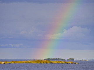End of the rainbow on a small island at the sea. Natural poster.
