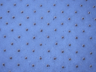 Old dotted metal checker plate texture closeup.