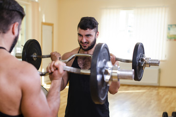 Fototapeta na wymiar the guy executes exercises in the gym
