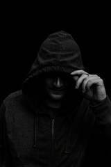 Fototapeta na wymiar Black and white Silhouette of a hooded man, isolated on black ba