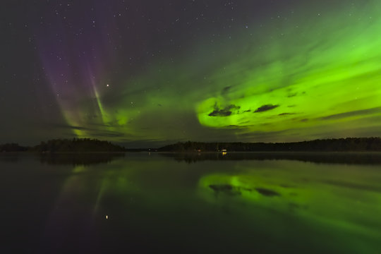 Beautiful green and purple northern lights over a lake. Natural poster.