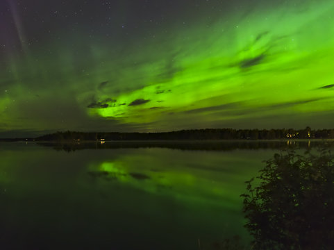 Green northern lights over a lake. Natural poster.