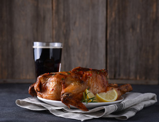 Chicken roasted with glass of drink on table