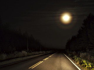 Night driving through dark forest highway in eerie moonlight. 