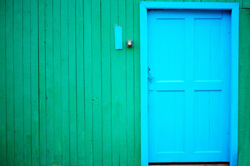 Wooden wall green color with the blue door