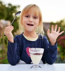 Petite fille mangeant une crème au chocolat 