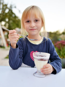 Petite fille mangeant une crème au chocolat 