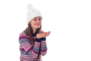 Woman in sweater and white hat holding something 