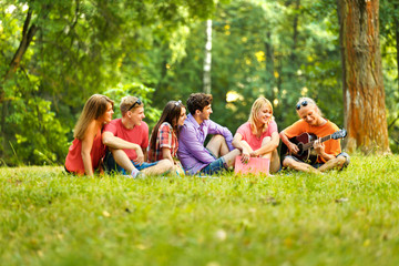  group of students with a guitar resting in the Park 
