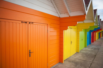 Row of bright colored beach huts.
