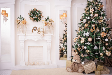 Christmas background. New Year interior design. Decorated tree near fireplace in great white living room.