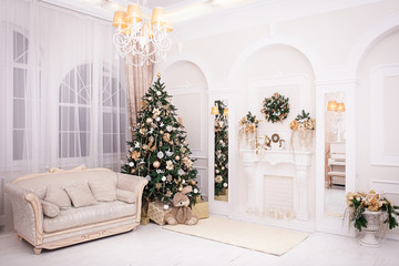 classic appartments with a white fireplace, decorated Christmas tree, bnight sofa, large windows and a chandelier in Baroque style