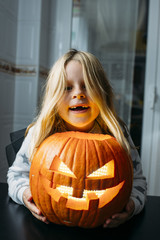 Cute child holding small pumpkin