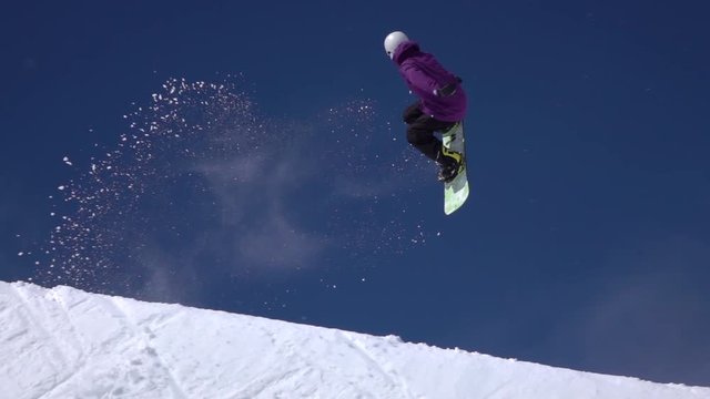 SLOW MOTION: Young pro snowboarder jumping in half pipe snow park