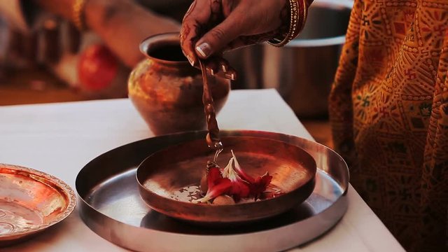 Hindu woman pours oil over the petals
