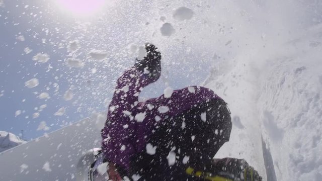 SLOW MOTION: Young pro snowboarder sliding on half pipe wall in sunny snowpark