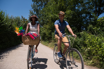 Fototapeta na wymiar Young multiethnic couple having a bike ride in nature
