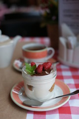 Tiramisu in a jar of glass on a table at a restaurant. 