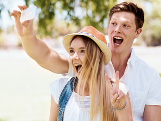 Obraz premium Young couple doing selfie outdoors