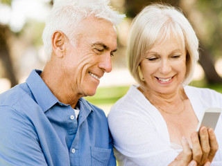 Happy senior couple looking at smartphone