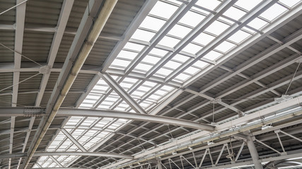 Gray and white metal roof structure in sunny day.