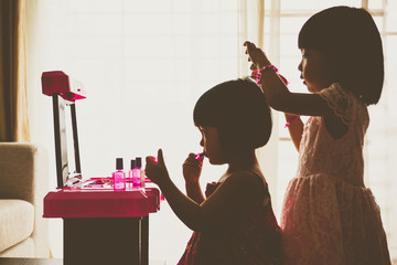 Silhouette Asian Chinese Liitle Sisters Playing With Make-Up Toy