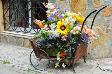 Fototapeta na wymiar Decorative wood cart with artificial flowers