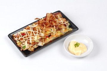 Japan pizza as "Okonomiyaki" is fried mixed vegetable flour with meat topped sweet sauce ,mayonnaise or salad cream and sliced dried yellowfin tuna served with side dish.
