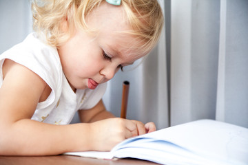 Little girl drawing at home